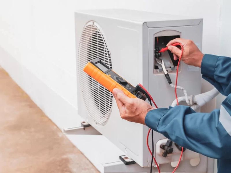 Technician measuring readings on an outdoor AC unit